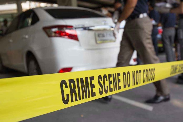 Crime scene tape blocking off white sedan.