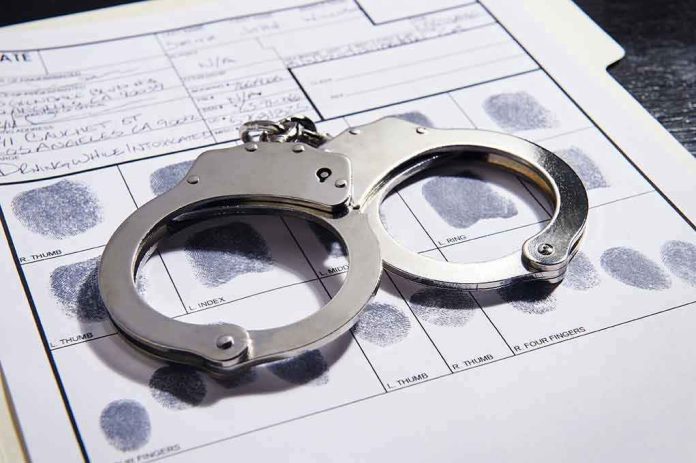 608376650 Handcuffs on fingerprint form with fingerprints visible