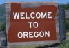 Welcome sign to Oregon with a brown background and white text