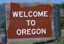 Welcome sign to Oregon with a brown background and white text