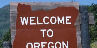 Welcome sign to Oregon with a brown background and white text