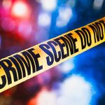 Yellow crime scene tape with blurred lights background