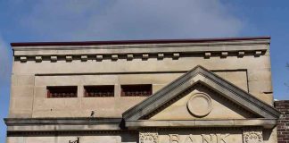 Stone building facade with bank sign and columns