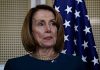 Pelosi Rips Crown: Bold Defiance or Stunt? Person standing near American flag indoors