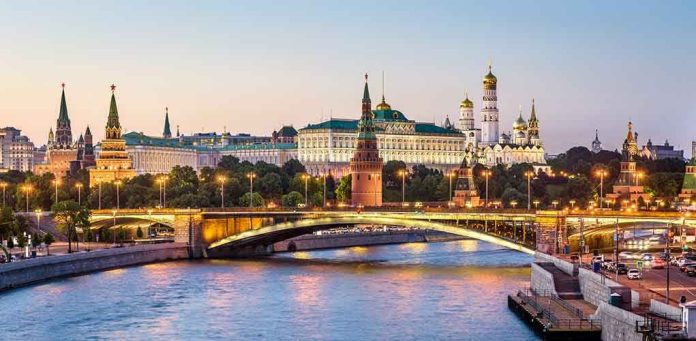 1419194690 Illuminated bridge and Kremlin complex across river at twilight