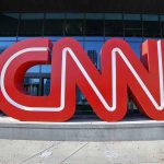 Large red CNN sign outside building entrance