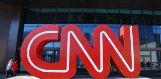 Large red CNN sign outside building entrance