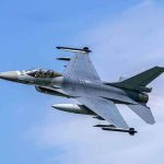 Jet fighter flying through clear blue sky