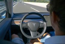 Tesla’s $1 Trillion Ultimatum Dares Shareholders Man using autopilot mode in a Tesla car