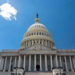 U.S. Capitol building against a clear blue sky.