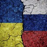 Cracked Ukrainian and Russian flags painted on concrete