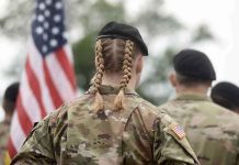 Soldier with braided hair in uniform American flag visible