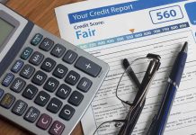 Calculator and glasses on credit report document