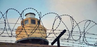 Barbed wire in front of a prison tower