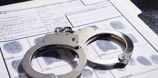 Handcuffs on fingerprint form with fingerprints visible