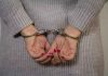 Teacher Trafficking Bombshell Shocks District Person in handcuffs with gray sweater