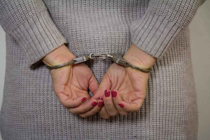 743870899 Person in handcuffs with gray sweater