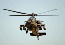 Military Apache helicopter flying in the sky