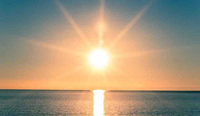 A serene sunrise over a calm ocean with vibrant colors in the sky