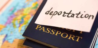 Stack of passports with a note labeled deportation on top placed on a map