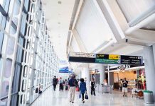 Interior of an airport terminal with travelers and signage