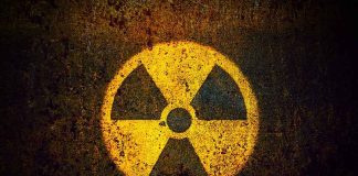 Yellow radiation warning symbol on rusty metal surface