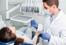 Dentist examining a patient in a dental chair.