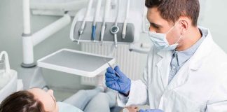 Dentist examining a patient in a dental chair.
