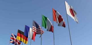 Owens’ Shocking Claim: Macrons’ Assassination Plot? Flags of seven countries against clear blue sky.