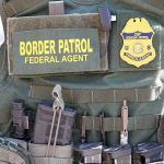 Massive Deportation Spree Rattles U.S. Cities Border Patrol vest with gear and communication equipment.