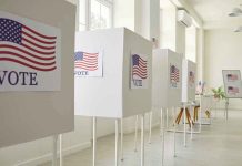 Voting booths with American flag and VOTE signs