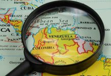 Trump’s Bold Move: Venezuela’s Drug War Heats Up Magnifying glass focusing on Venezuela and Colombia on map