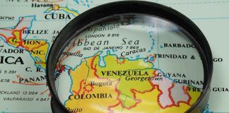 Magnifying glass focusing on Venezuela and Colombia on map
