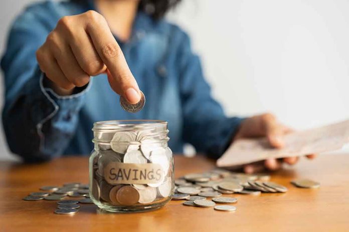 Person placing a coin into a savings jar labeled 'SAVINGS'