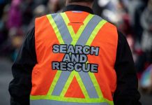 Person wearing a bright orange search and rescue vest