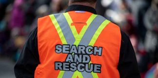 Person wearing a bright orange search and rescue vest