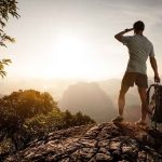 Shocking Failure in Wildlife Safety Exposed Hiker standing on a rocky outcrop overlooking a valley at sunset