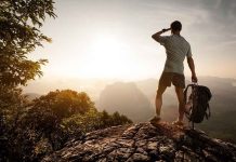 Shocking Failure in Wildlife Safety Exposed Hiker standing on a rocky outcrop overlooking a valley at sunset