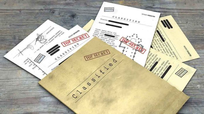 1099529729 Classified documents with Top Secret stamps on wooden surface.