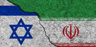 Jihad Chants At Parade Ignite Israel War Fears Israeli and Iranian flags divided by a cracked line.