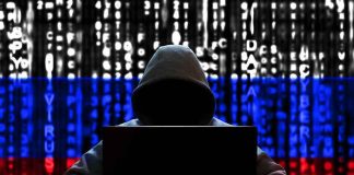 Hacker in hoodie with Russian flag background and code.