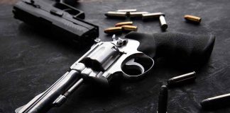 Revolvers and bullets on a dark surface.