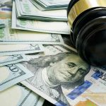 Farmers Caught in Tariff Crossfire! Gavel and hundred dollar bills on table.