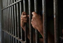 Florida Dating-App Date Turns Into Dismembered Nightmare Hands gripping prison cell bars tightly.