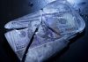 Catastrophic Crash Threatens to Destabilize Global Markets Hundred-dollar bills frozen in cracked ice block.