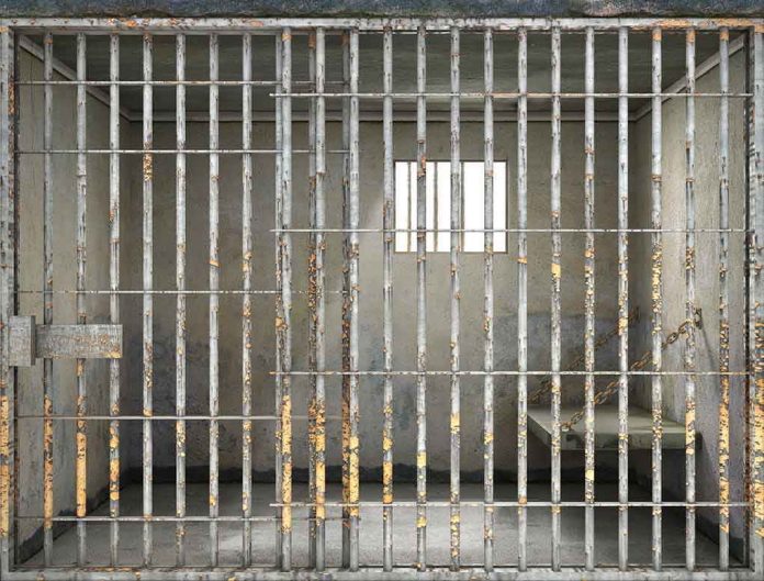 508424233 Empty rusty prison cell with a small window.