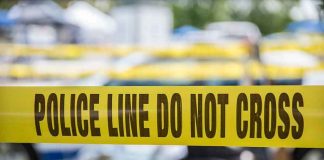 Yellow police line tape with Do Not Cross.