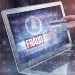 Taxpayer Nightmare: Somali Fraud Scandal Unfolds Person holding credit card near laptop displaying Fraud.