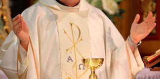 A priest holding a golden chalice during a religious ceremony