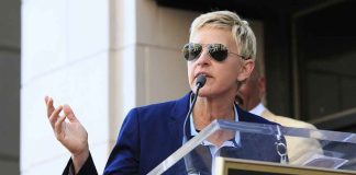 UK Villagers REJECT Ellen—Community Clash Unfolds A woman in sunglasses speaking at a podium during an outdoor event